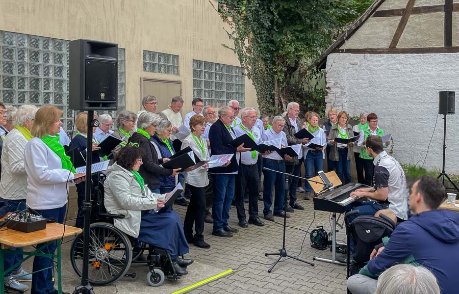 Der gemischte Chor "VokalGenial" des MGV WIndesheim mit seinem Chorleiter Daniel Speer beim Offenen SIngen am 29.09.2024, auf dem Platz neben dem Rathaus in Windesheim. 